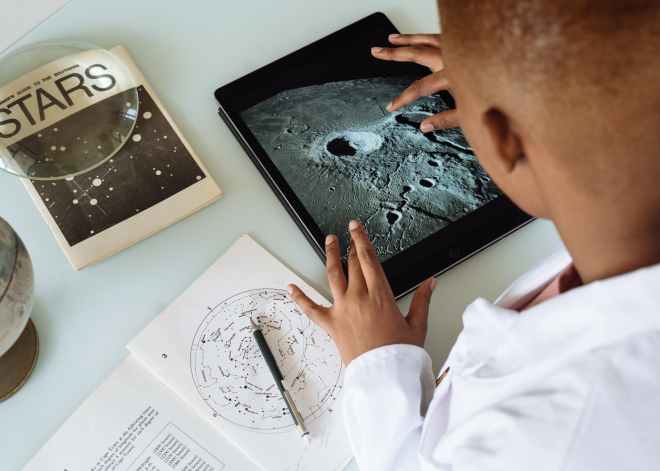 crop african american student studying craters of moon on tablet at observatory